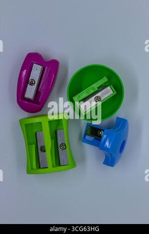 Verschiedene Bleistiftspitzer in Grün, Blau und Lila auf einer sauberen Oberfläche. Perfekt für Schulbedarf, Büromaterial und Kunstwerkzeuge Stockfoto