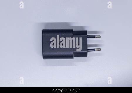 Nahaufnahme eines schwarzen superschnellen Ladeadapters mit kompaktem, modernem Design. Ideal für Elektronik, mobiles Zubehör, Stromversorgungslösungen. Stockfoto