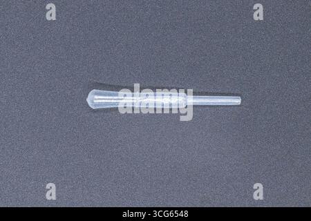 Nahaufnahme einer durchsichtigen Kunststoffpipette zur präzisen Flüssigkeitsmessung im Labor. Medizinisches und wissenschaftliches Gerätekonzept mit sterilem Material. Stockfoto