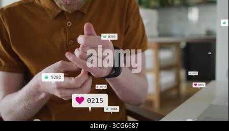 Anpassen des Drehrings des Seniorenmannes zu Hause, mit Laptop- und schwimmenden Smartwatch-Kennzahlen Stockfoto