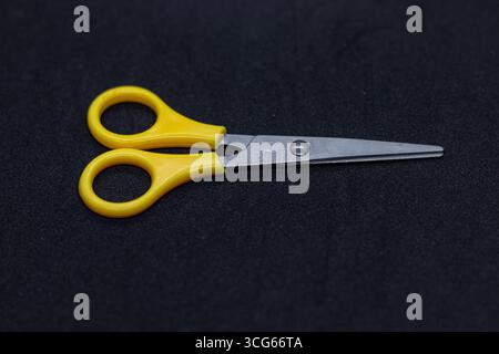 Kompakte Sicherheitsschere mit hellgelben Kunststoffgriffen und Metallklingen, ideal für Kinder, Bastelarbeiten und Schulen. Kinderfreundliches Design, sicherer Schnitt Stockfoto