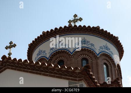 Die Kuppel der Kirche des Heiligen Erzengels in Plovdiv, Bulgarien, mit dekorativem Ziegelwerk, Bogenfenstern mit Buntglas und blauem Blumenpas Stockfoto