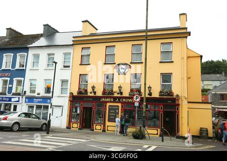 Cork, Irland - 14. Juli 2025 - Eine Straßenszene mit einem gelb bemalten Pub, wie sie an einem bewölkten Nachmittag in Bantry, County Cork, zu sehen ist Stockfoto