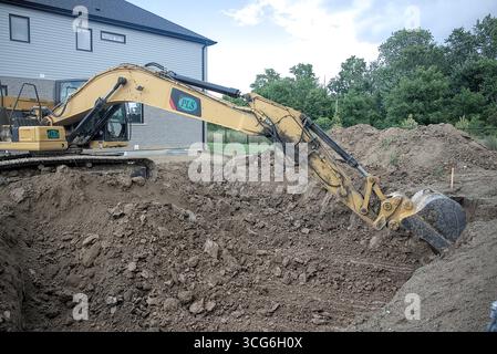 Bagger gräbt ein großes Loch für ein neues Gebäude. Stockfoto