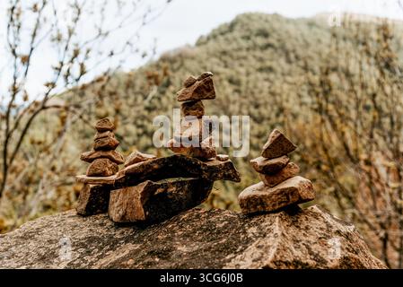 Kleine Steine in Pyramiden auf großen Kopfsteinpflastersteinen gestapelt, Zen und Gleichgewicht in der Natur Stockfoto