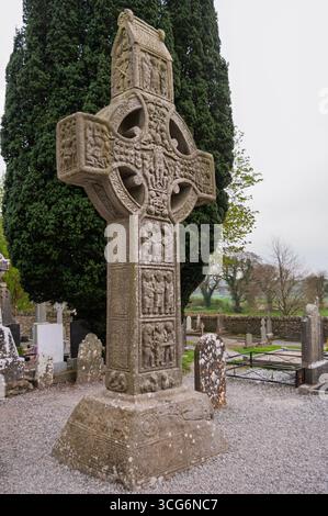 Ein großes Steinkreuz mit einem Kreuz darüber. Das Kreuz ist von einem Friedhof umgeben Stockfoto