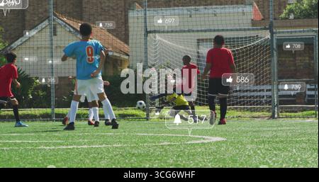 Gelber Torhüter, der auf dem Fußballfeld mit Ball und Benachrichtigungssymbolen auf dem Rasen spart Stockfoto