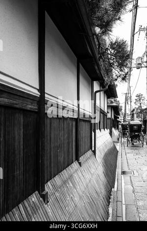 Schwarzweiß-Foto mit Bambus Inuyarai oder Hundebarriere an der Seite traditioneller japanischer Gebäude, Kinencho, Higashiyama Ward, Kyoto, Stockfoto