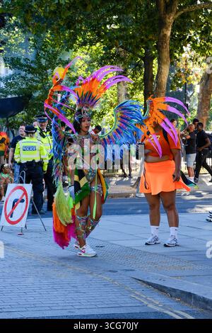 Kostümliebhaber bereiten sich darauf vor, den Karneval in Notting Hill nach einem langen Tag in der Sonne am Montag an Feiertagen zu verlassen. Stockfoto