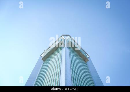 Hochhaus, vor blauem Himmel. Niedriger Winkel, Kopierraum. Stockfoto