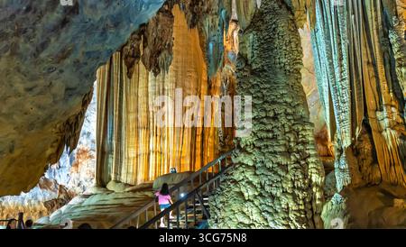 Touristen besuchen auf hölzernen Gehweg durch die malerische Natur Flur Paradies Höhle mit Stalaktiten und Stalagmiten in Phong Nha National Park, Quang Binh Stockfoto