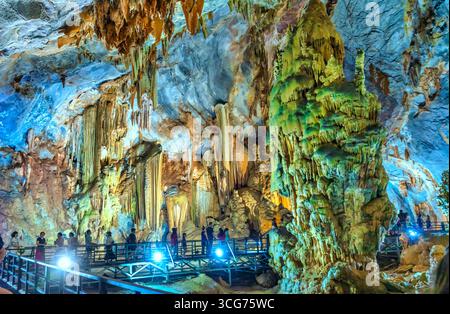 Touristen besuchen auf hölzernen Gehweg durch die malerische Natur Flur Paradies Höhle mit Stalaktiten und Stalagmiten in Phong Nha National Park, Quang Binh Stockfoto