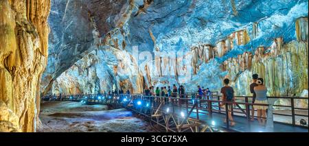 Touristen besuchen auf hölzernen Gehweg durch die malerische Natur Flur Paradies Höhle mit Stalaktiten und Stalagmiten in Phong Nha National Park, Quang Binh Stockfoto