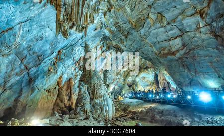 Touristen besuchen auf hölzernen Gehweg durch die malerische Natur Flur Paradies Höhle mit Stalaktiten und Stalagmiten in Phong Nha National Park, Quang Binh Stockfoto