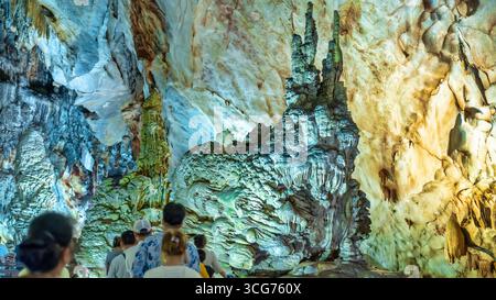 Touristen besuchen auf hölzernen Gehweg durch die malerische Natur Flur Paradies Höhle mit Stalaktiten und Stalagmiten in Phong Nha National Park, Quang Binh Stockfoto