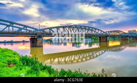 Sonnenaufgang bei Sonnenaufgang an der Trang Tien Bridge in Hue, Vietnam. Dies ist eine gotische architektonische Brücke, die den Parfümfluss aus dem 18. Jahrhundert überspannt und von entworfen wurde Stockfoto