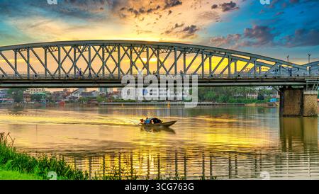 Sonnenaufgang bei Sonnenaufgang an der Trang Tien Bridge in Hue, Vietnam. Dies ist eine gotische architektonische Brücke, die den Parfümfluss aus dem 18. Jahrhundert überspannt und von entworfen wurde Stockfoto