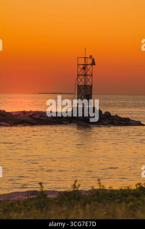 Sonnenuntergang über Montauk Harbor Eingang mit Beacon, Long Island, New York, USA Stockfoto