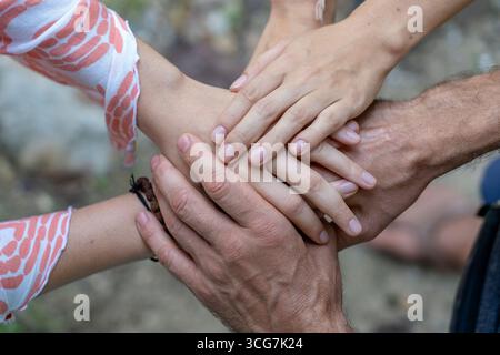 Arm eins zusammen gestapelt in Einheit und Teamarbeit. Viele Hände treffen sich in der Mitte eines Kreises. Close Up Outdoor geschossen. Viele Hände connec Stockfoto
