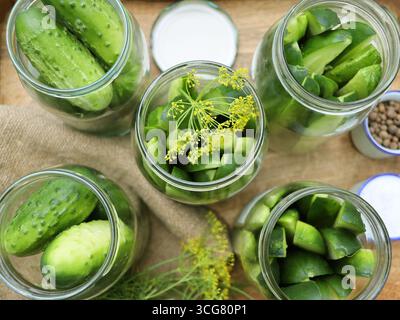 Köstliche eingelegte Gurken in einem Glas in einer Holzkiste, Gewürze, Kräuter auf einem Tisch. Herstellung von Gurken für Gurken für Gurken Stockfoto