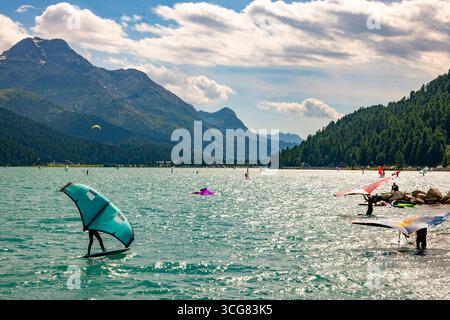 Wingsurfen auf dem Alpensee Silvaplana an einem sonnigen Sommertag mit Bergblick in Silvaplana, Maloja, Graubünden, Schweiz. Stockfoto