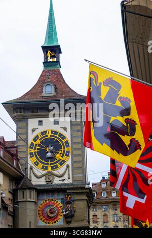 Wunderschöne alte Hauptstraße mit altem Gebäude und Flaggen an einem regnerischen Tag in Bern, Kanton Bern, Schweiz. Stockfoto