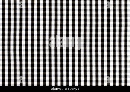 Textur eines Gewebes in einem Käfig. Schwarz-weiß karierter Stoff. Stockfoto