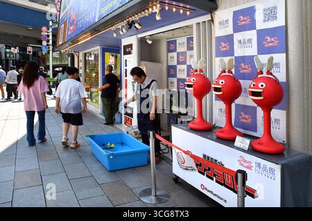 der Eingang des berühmten Hakuhinkan Toy Park-Ladens in Ginza, Tokio, mit drei roten interaktiven Klatschrobotern Big Clappy draußen - Japan Stockfoto