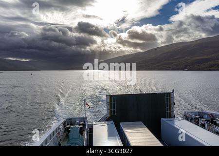 Blick auf das Fährdeck mit Lastwagen an Bord unter dramatischen Sturmwolken Stockfoto