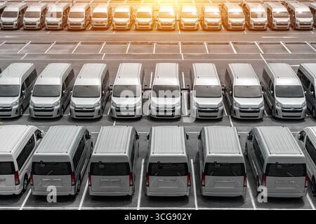 Mehrere Pkw Lieferwagen LKW auf dem Parkplatz zur Anmietung Lieferung weiße Lieferwagen im Service-Lieferwagen LKW vor dem Eingang des Lagerverteilers Logistik. Stockfoto