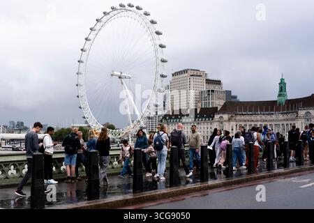 Fußgänger gehen vor dem London Eye in Westminster, London. Bilddatum: Mittwoch, 27. August 2025. Stockfoto