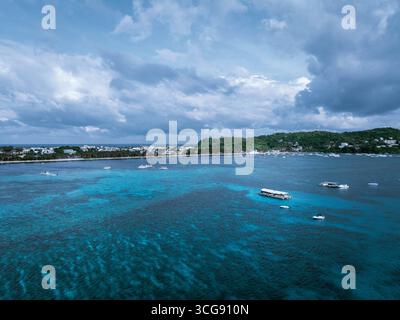 Aus der Vogelperspektive trifft man auf die Sandküste von Boracay, einem lebendigen Wandteppich des Insellebens unter bewölktem Himmel, Malaiisch, Western Visayas, Philippinen. Stockfoto