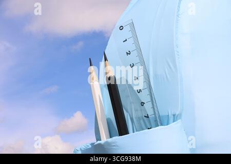 Holzstifte und Messstab gegen den blauen Himmel. Hintergrund für den Schultag Stockfoto