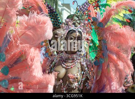 London, Großbritannien - 25. August 2025 - ein Darsteller, der am Notting Hill Carnival in West London teilnimmt, in lebendiger Kleidung und einem ausgeklügelten Kostüm Stockfoto