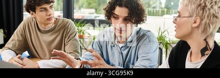 Drei junge Berufstätige führen eine kreative Diskussion und tauschen Ideen und Erkenntnisse aus. Stockfoto