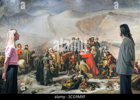 London, Großbritannien. August 2025. Museum Staff mit „The Capitulation of Kars, 28 November 1855“ (1857) von Thomas Jones Barker, ein Werk in dieser Ausstellung. Das National Army Museum hat zeitgenössische Künstler beauftragt, ikonische viktorianische Militärbilder in der Ausstellung „Myth and Reality: Military Art in the Age of Queen Victoria“ im Museum neu zu interpretieren. Quelle: Imageplotter/Alamy Live News Stockfoto