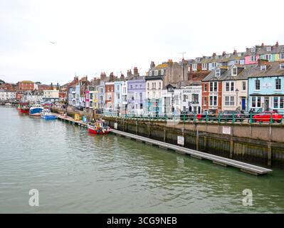 Fischerboote auf dem Fluss am Weymouth Harbour in Dorset, England mit alten Gebäuden am Hafen. Stockfoto