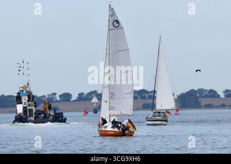 Wismar, Deutschland. August 2025. Segelboote segeln bei gemäßigtem Wind in der Bucht von Wismar in Richtung Poel an der Ostsee. Teilweise sonnig und bei Temperaturen um 25 Grad zeigt das Wetter in Norddeutschland seine freundliche Seite. Quelle: Jens Büttner/dpa/Alamy Live News Stockfoto