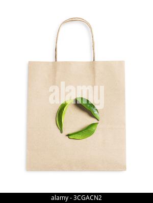 Umweltfreundliche Verpackung. Eine Papiertüte und ein Recycling-Symbol aus Blättern, die auf weiß isoliert sind, Draufsicht Stockfoto