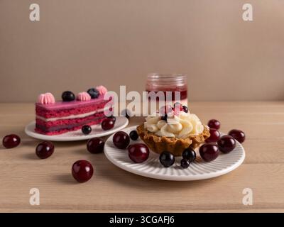 Aus nächster Nähe sehen Sie verschiedene Beerendesserts auf Tellern mit rustikalem Holztisch Stockfoto