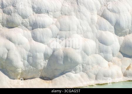 Großer weißer Felsen mit vielen Unebenheiten und Graten. Der Stein ist weiß und hat eine große Textur Stockfoto