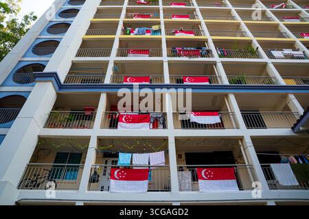Singapur-Flaggen auf den Balkonen der Apartments zur Feier des Nationalfeiertags symbolisieren Stolz, Einheit und Patriotismus. Stockfoto