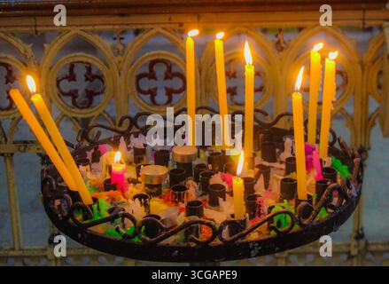 Warme Glühkerzen sorgen für ein ruhiges, stimmungsvolles Licht und schaffen eine friedliche und gemütliche Atmosphäre für Meditation, Entspannung oder festliche Einrichtung. Stockfoto