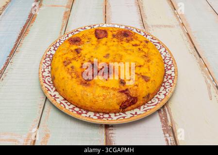 Spanisches Omelett goldbraun auf beiden Seiten, mit sichtbar zarten Kartoffeln und transparenten Zwiebelstücken zwischen den Schichten Stockfoto