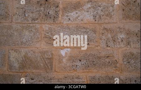 Nahaufnahme einer Steinmauer mit verwitterter Kalksteinstruktur, perfekt für Design und Hintergründe Stockfoto