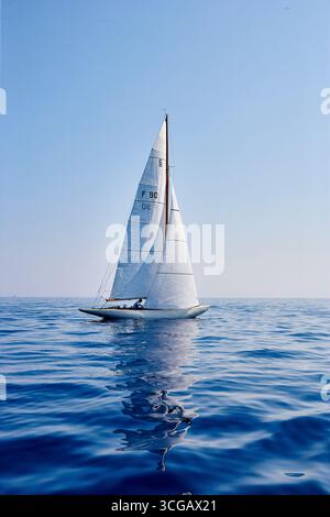Elegantes Segelboot auf ruhigem Wasser unter einem klaren blauen Himmel Stockfoto