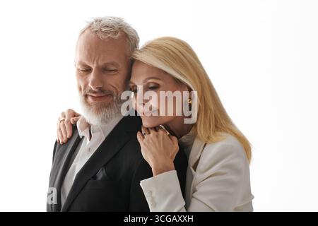 Das Seniorenpaar teilt einen zärtlichen Moment, während es in modischer Kleidung gekleidet ist und Liebe und Freude ausstrahlt. Stockfoto