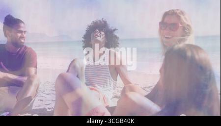 Lächelnd und lachend vier Freunde sitzen an der Sandküste, mit roter Sonnenbrille und Handtuch Stockfoto