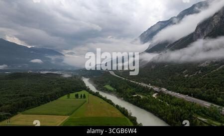 Inntal bei Haiming in Tirol, Österreich, mit niedrigen Wolken, die die Berge bedecken, und einer Autobahn neben dem Inn Stockfoto