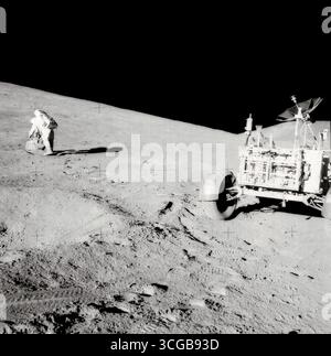 Scott am Hang des Hadley Delta. Astronaut David mission Kommandant, mit Zange und Gnomon in der hand, Studien ein Felsblock am Hang des Hadley Delta während der Apollo 15 lunar surface Extravehicular Tätigkeit. Das Lunar Roving Vehicle (LRV) oder Rover ist im rechten Vordergrund. Etwas blickt südlich von Westen. "Bennett Hill" ist bei extremen Rechten. Astronaut James B. Irwin, Pilot der Mondlandefähre, nahm dieses Foto. Fotograf: NASA /James B. Irwin. Stockfoto
